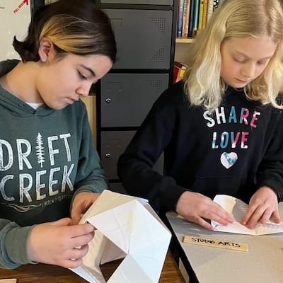 Two teenage students working on circle folding in a wholemovement workshop