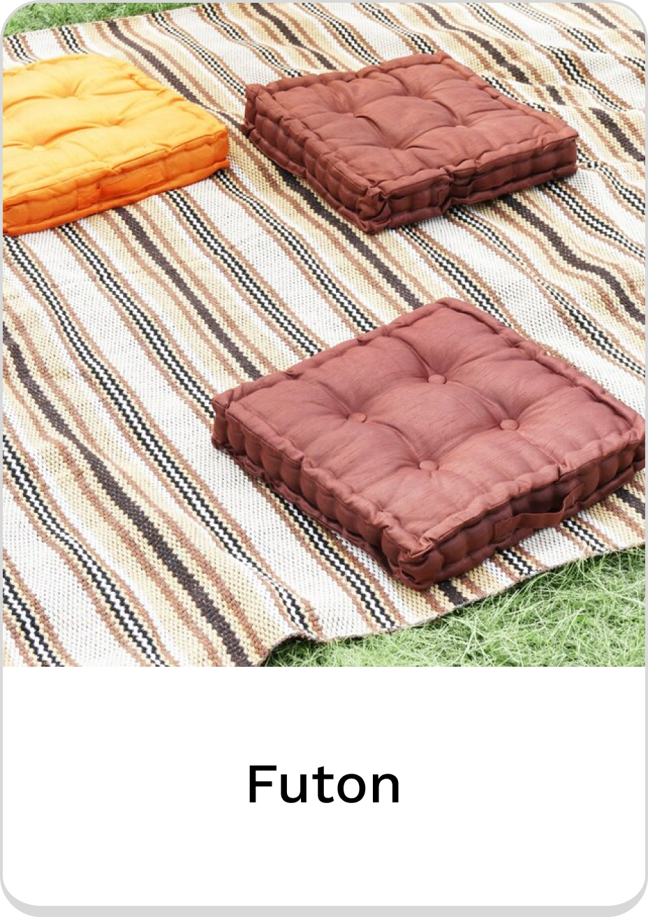 Orange and brown futon cushions on a colorful striped mat.