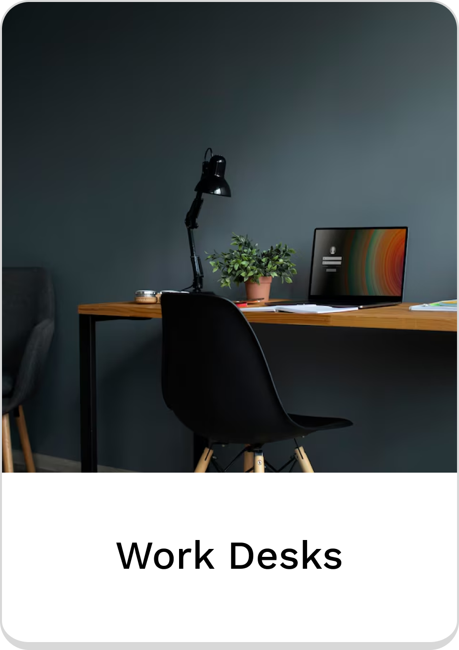Modern work desk setup with lamp, plant, and laptop in a stylish office.