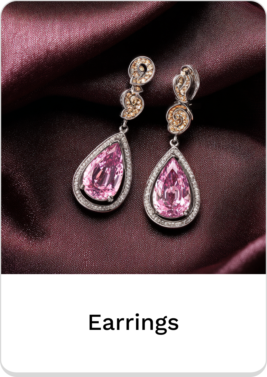 Elegant pink teardrop earrings with sparkling accents on luxurious fabric backdrop.