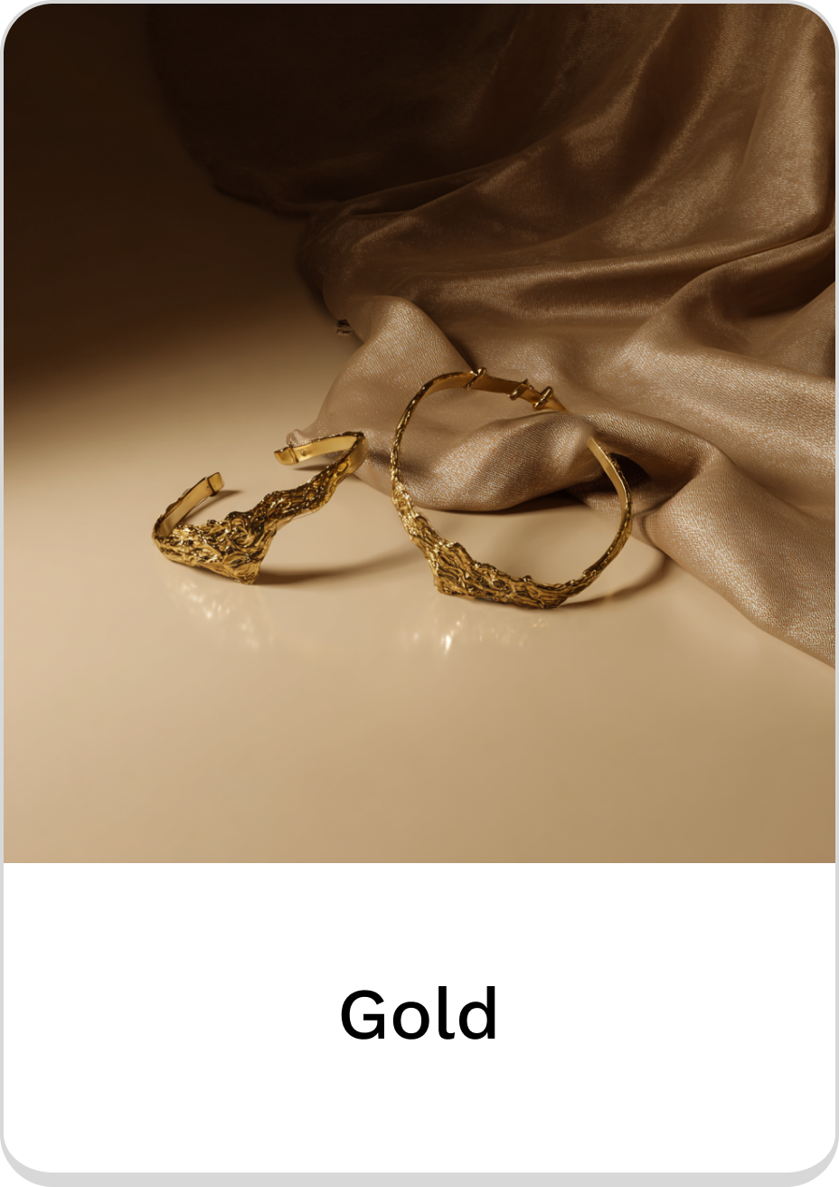 Elegant gold jewelry pieces displayed on a soft fabric background.