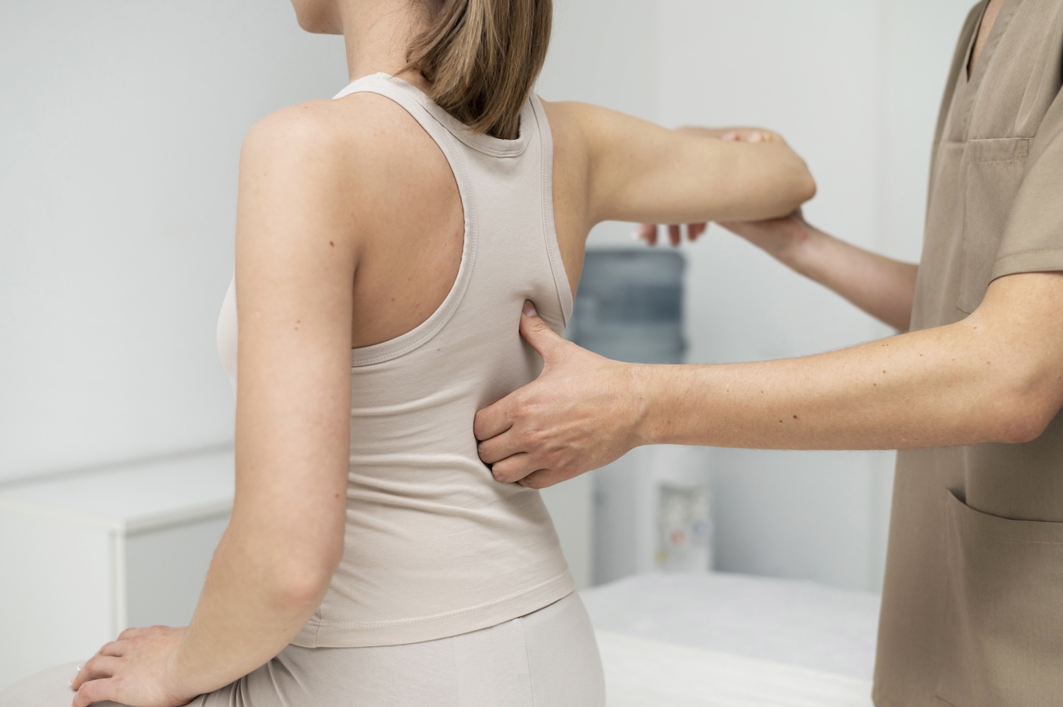 A woman has her back pain treated by a physiotherapist