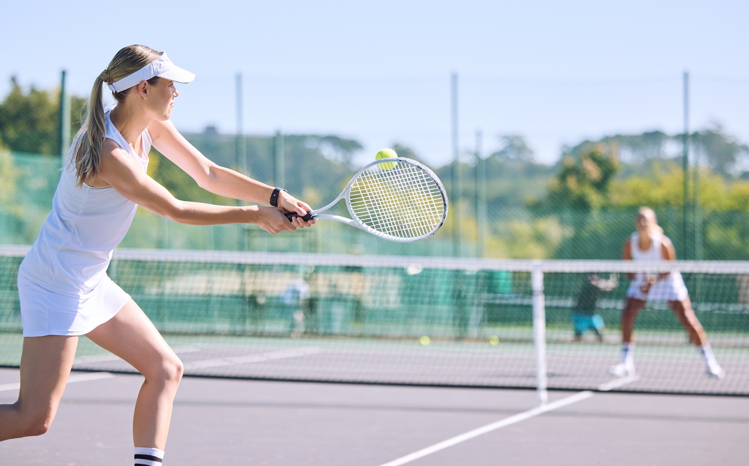 Zwei Frauen spielen zusammen Tennis.