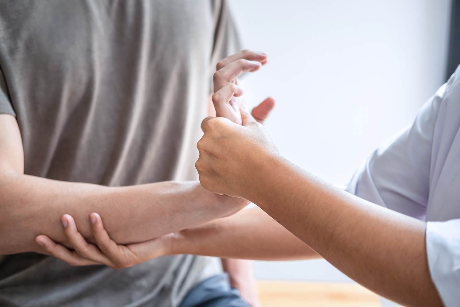 A person having their wrist pain treated by a physiotherapist.
