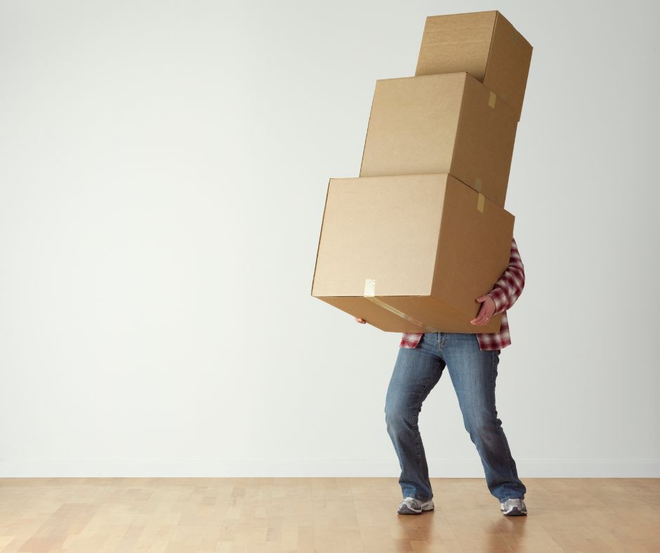 someone holding a bunch of boxes stacked on top of eachother