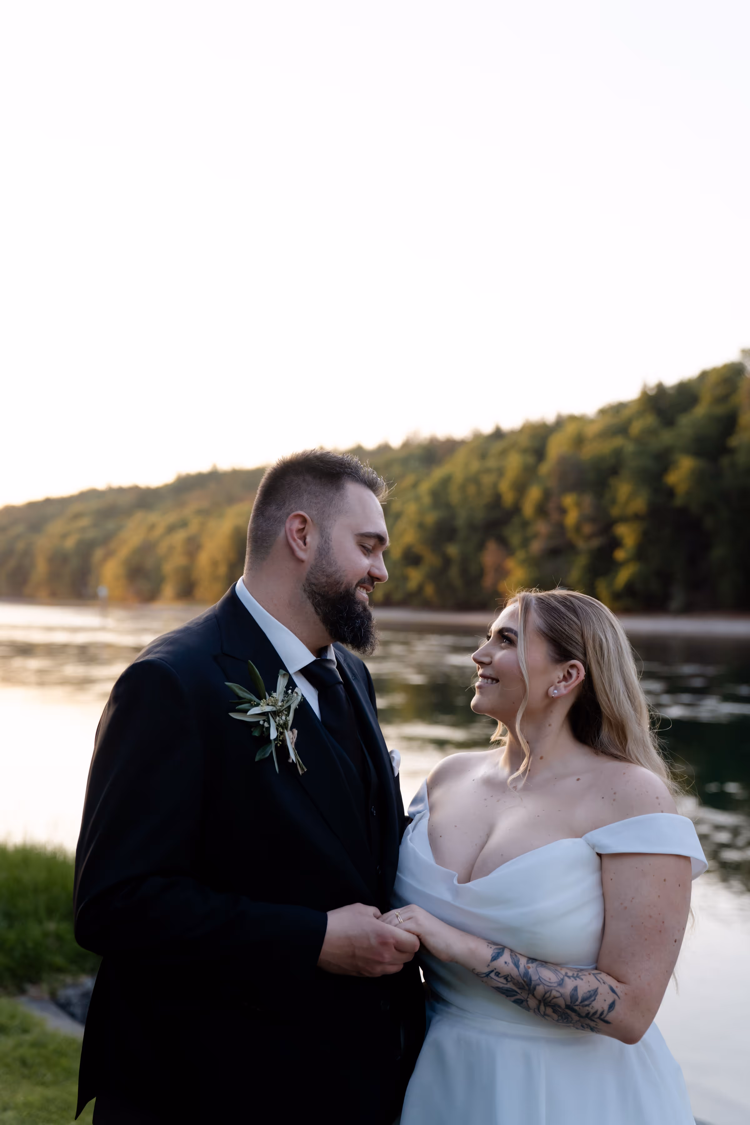 Glückliches Brautpaar feiert Traumhochzeit in der Schweiz, direkt am Rhein. Beide sind enorm entspannt, da die Hochzeit von einer professionellen Hochzeitsplanerin organisiert wurde.
