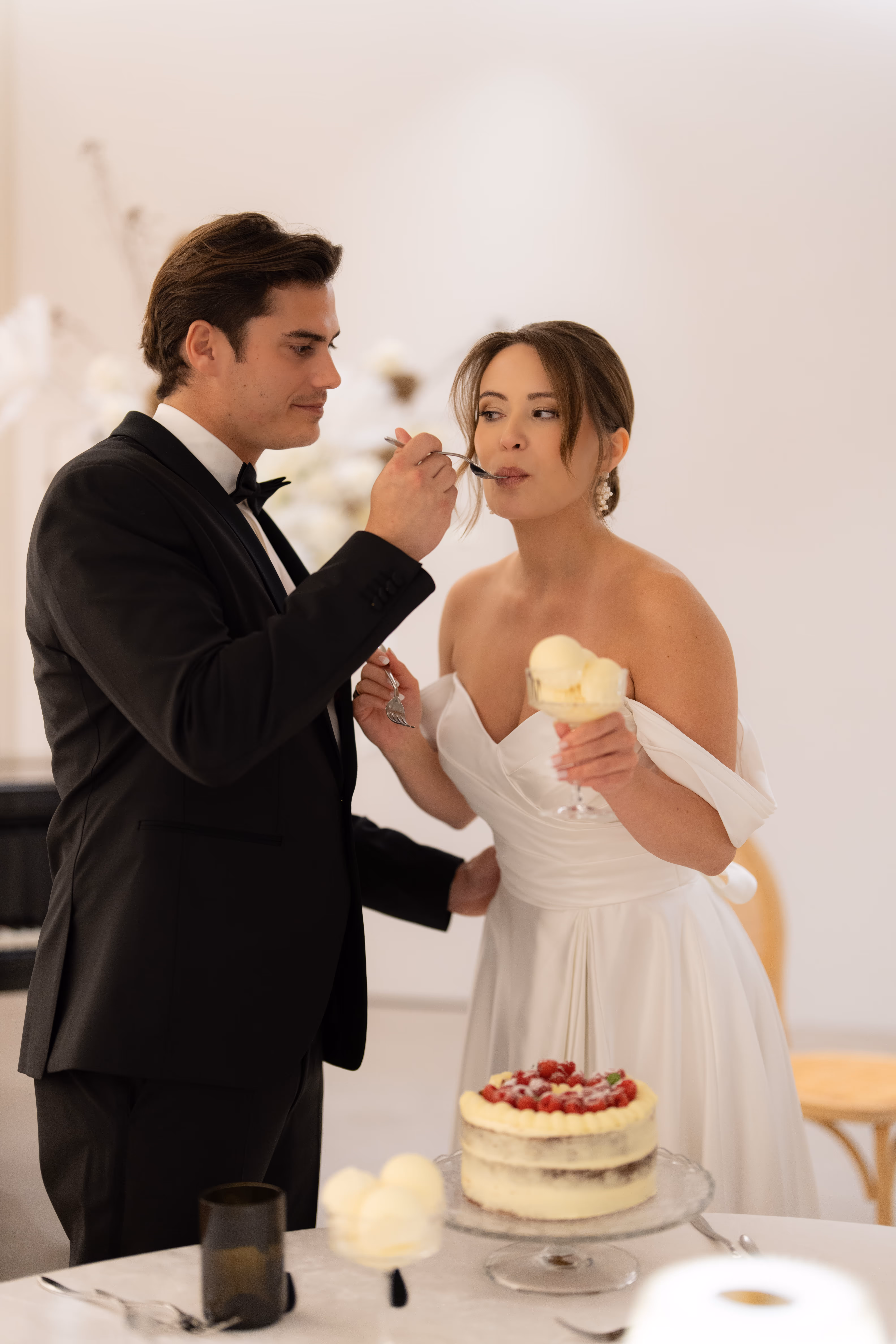 Braut und Bräutigam gemeinsam an ihrer geplanten Hochzeit in Schaffhausen. Mann füttert Ehefrau verspielt mit einem Dessert.