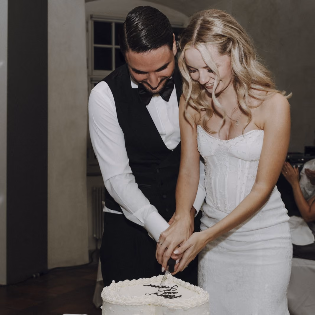 Brautpaar aus Schaffhausen an ihrer Hochzeit schneidet Hochzeitskuchen an.