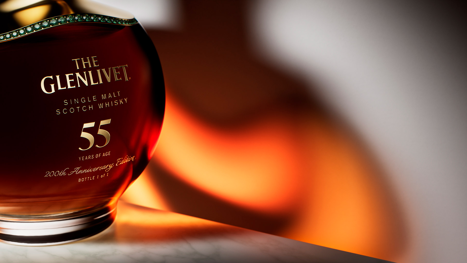The reflection of the liquid from The Eternal Collection 55-year-old bottle on the white wall.