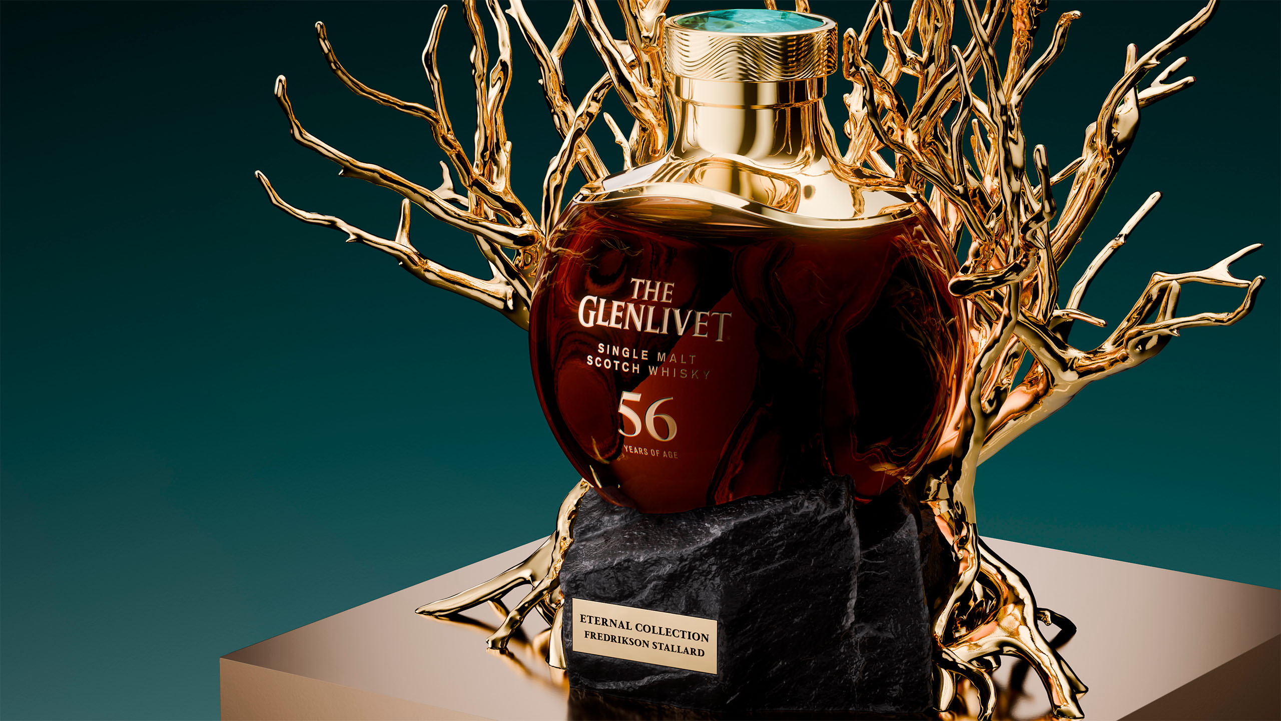 The Glenlivet 56 Year Old single malt whisky bottle cradled within sculptural gold branches on a dark stone base.