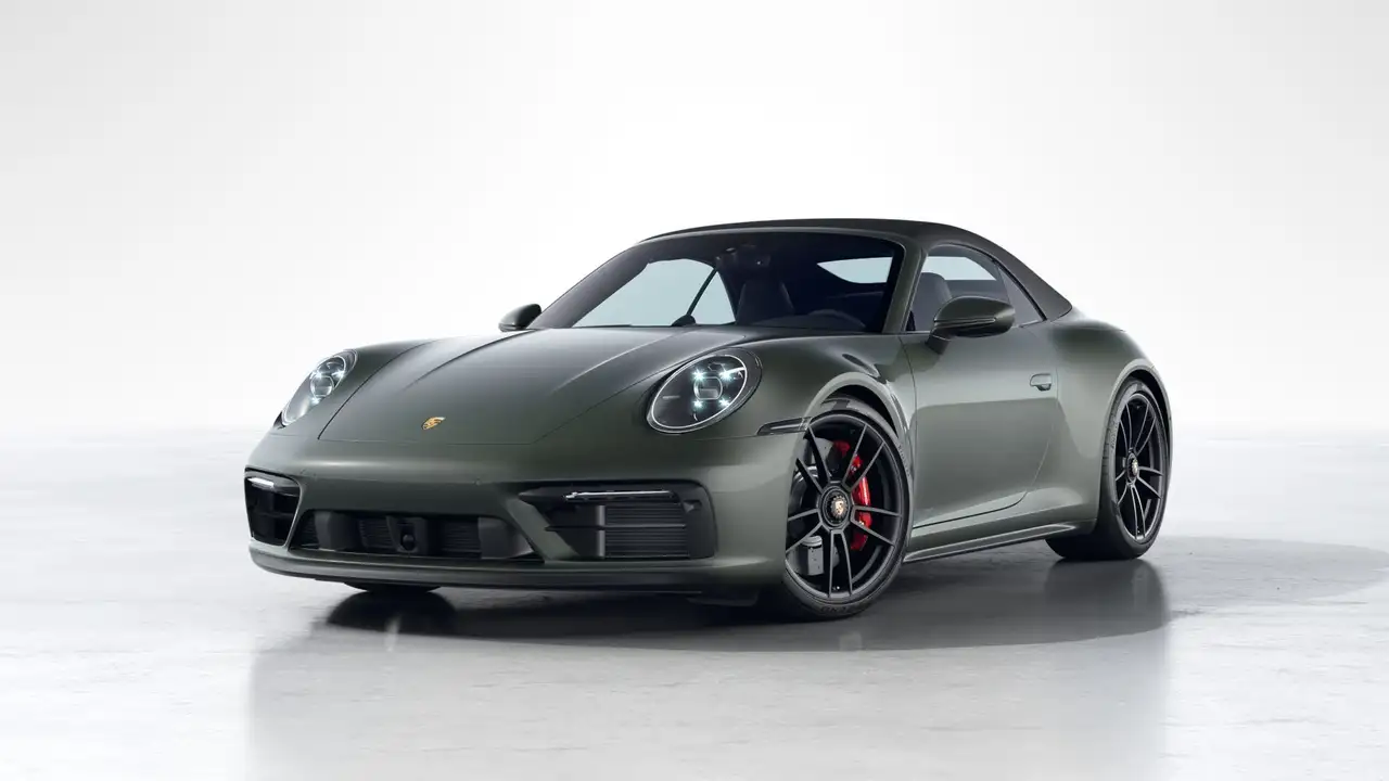 Green Porsche 911 convertible sports car angled front view on a white background.