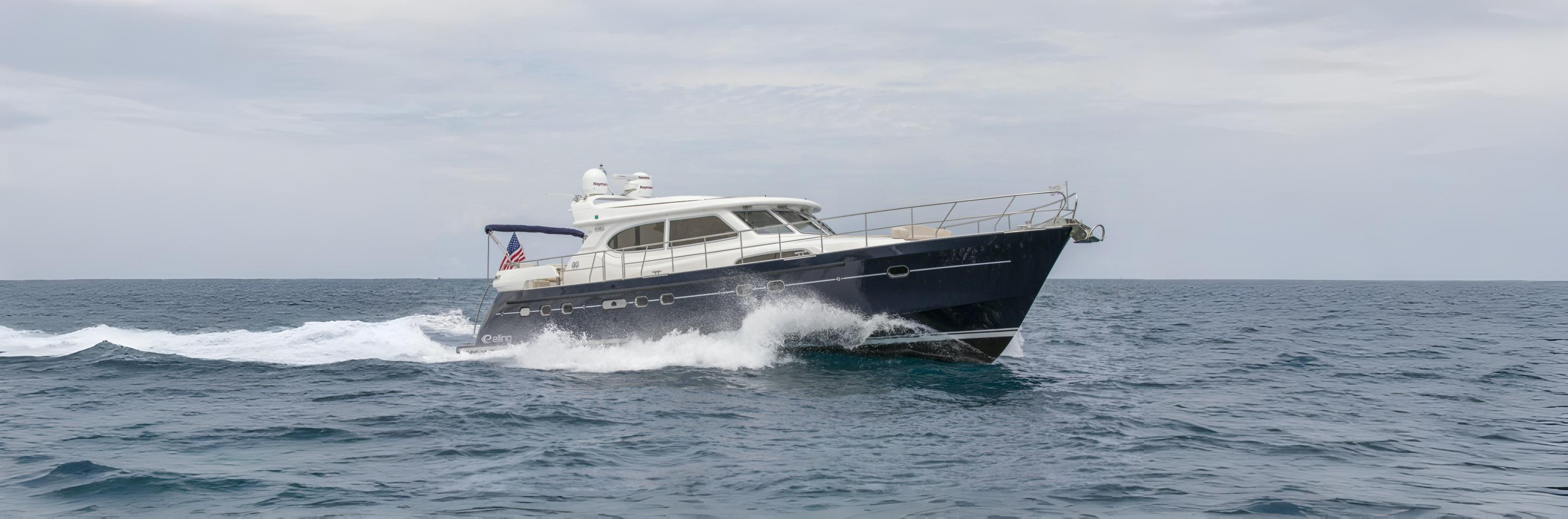 A sleek motor yacht cruising through choppy ocean waters under a cloudy sky.