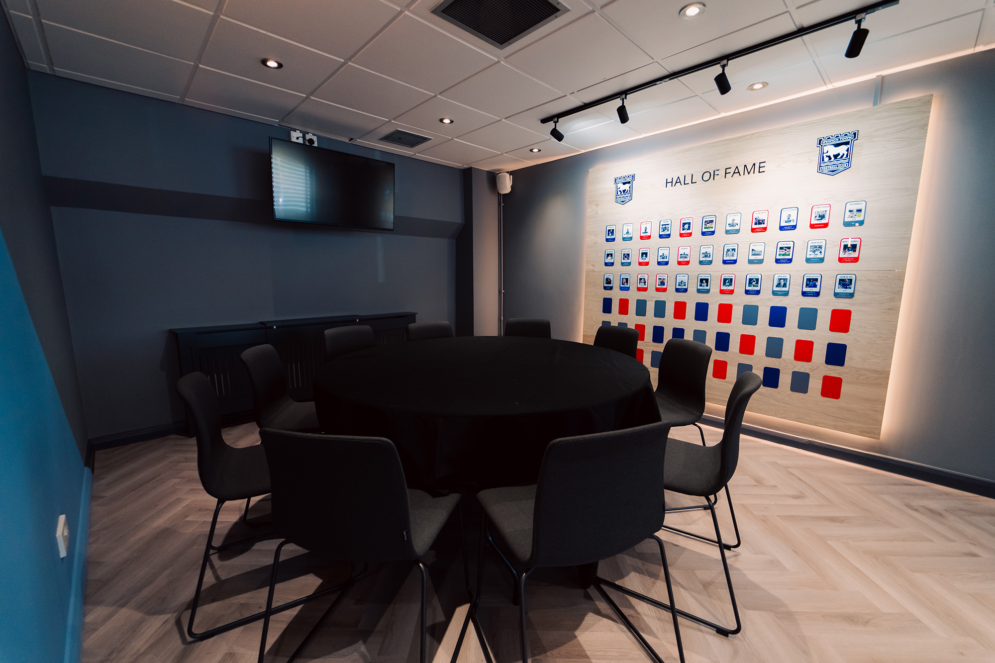 A directors lounge at Ipswich stadium with views to the pitch, showcasing interior design, furniture and bar
