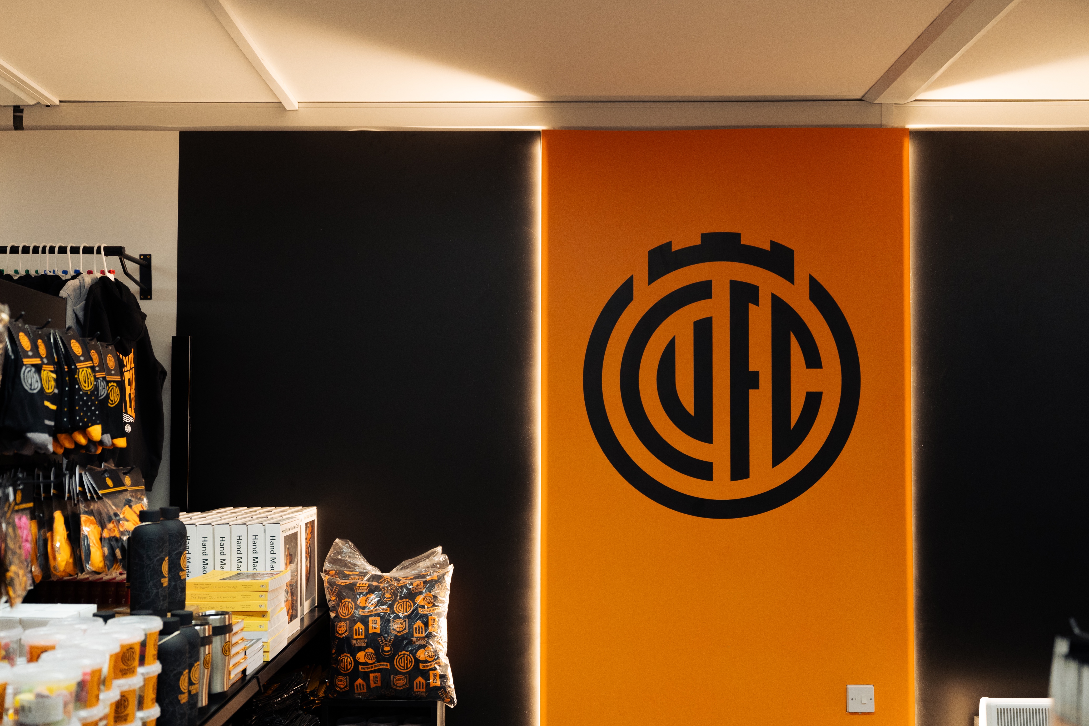 Retail space with orange and black football logo displayed on the wall