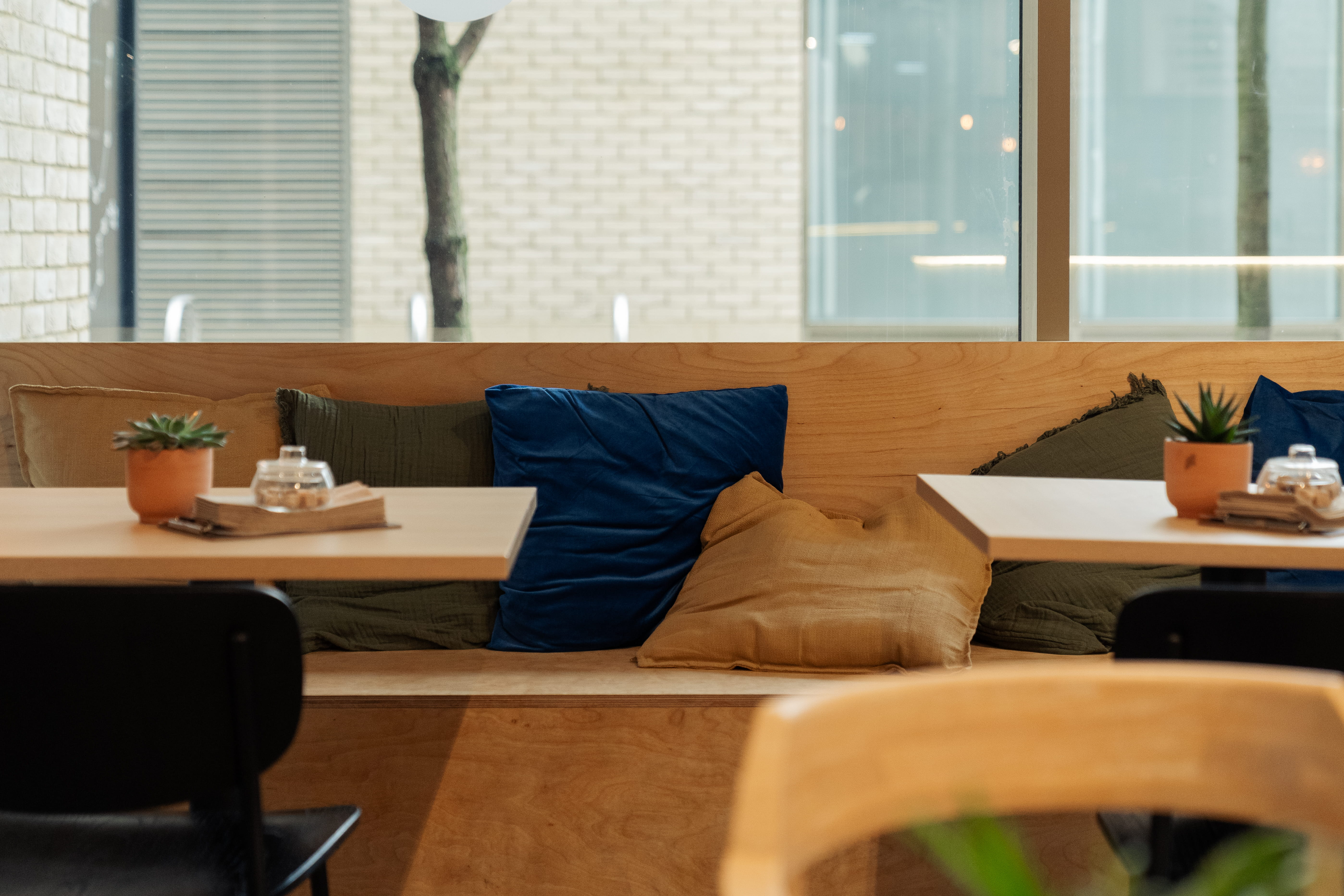 wooden cafe bench covered in blue and brown cushions