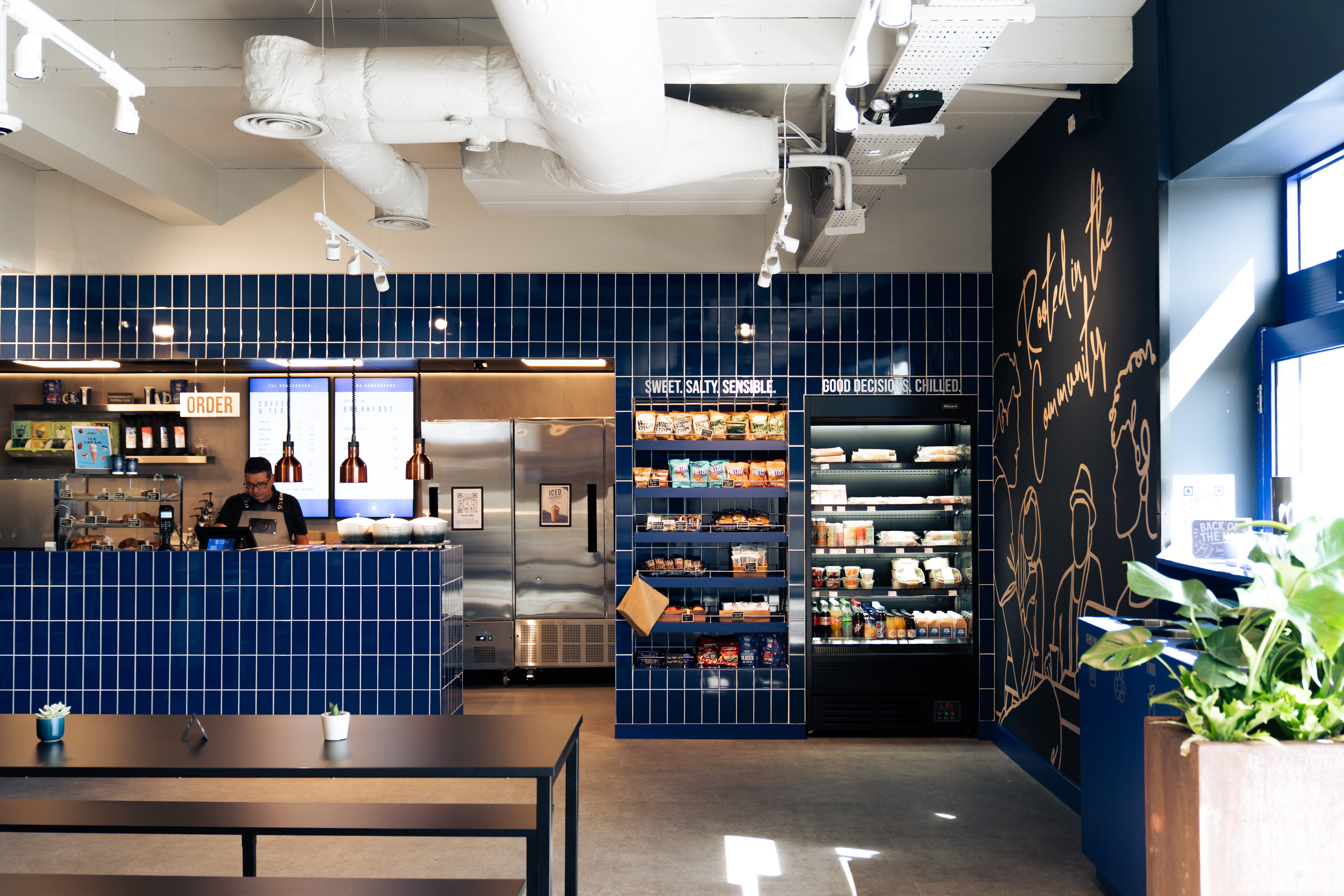 A directors lounge at Ipswich stadium with views to the pitch, showcasing interior design, furniture and bar