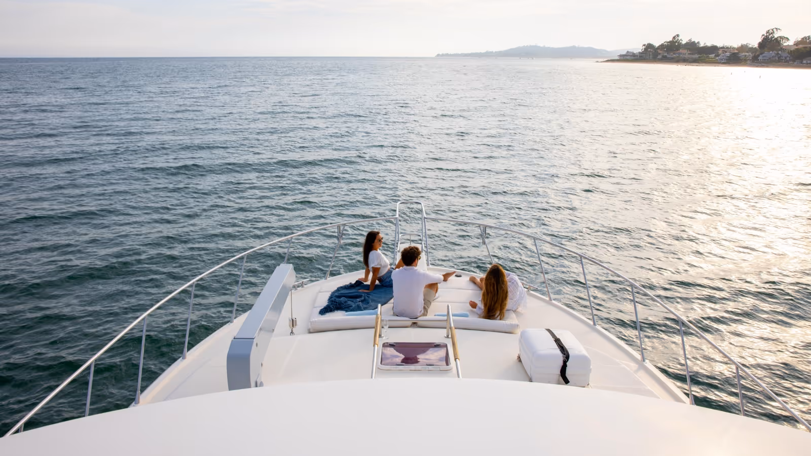 A photo of the New York City skyline at dusk with a distant Empire State Building lit in red at its crown.