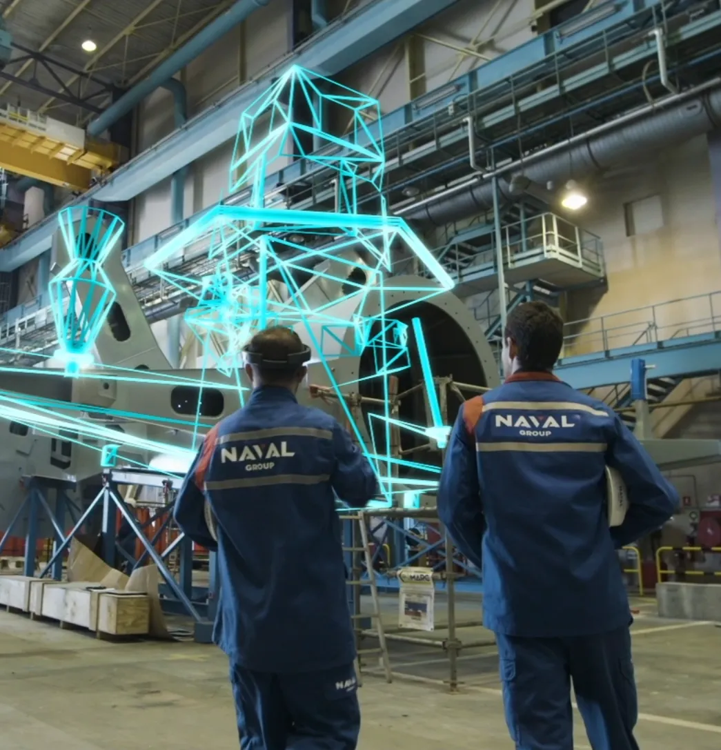 Techniciens du Naval Group utilisant un casque de réalité mixte pour visualiser en hologramme la structure 3D d’un navire en chantier naval