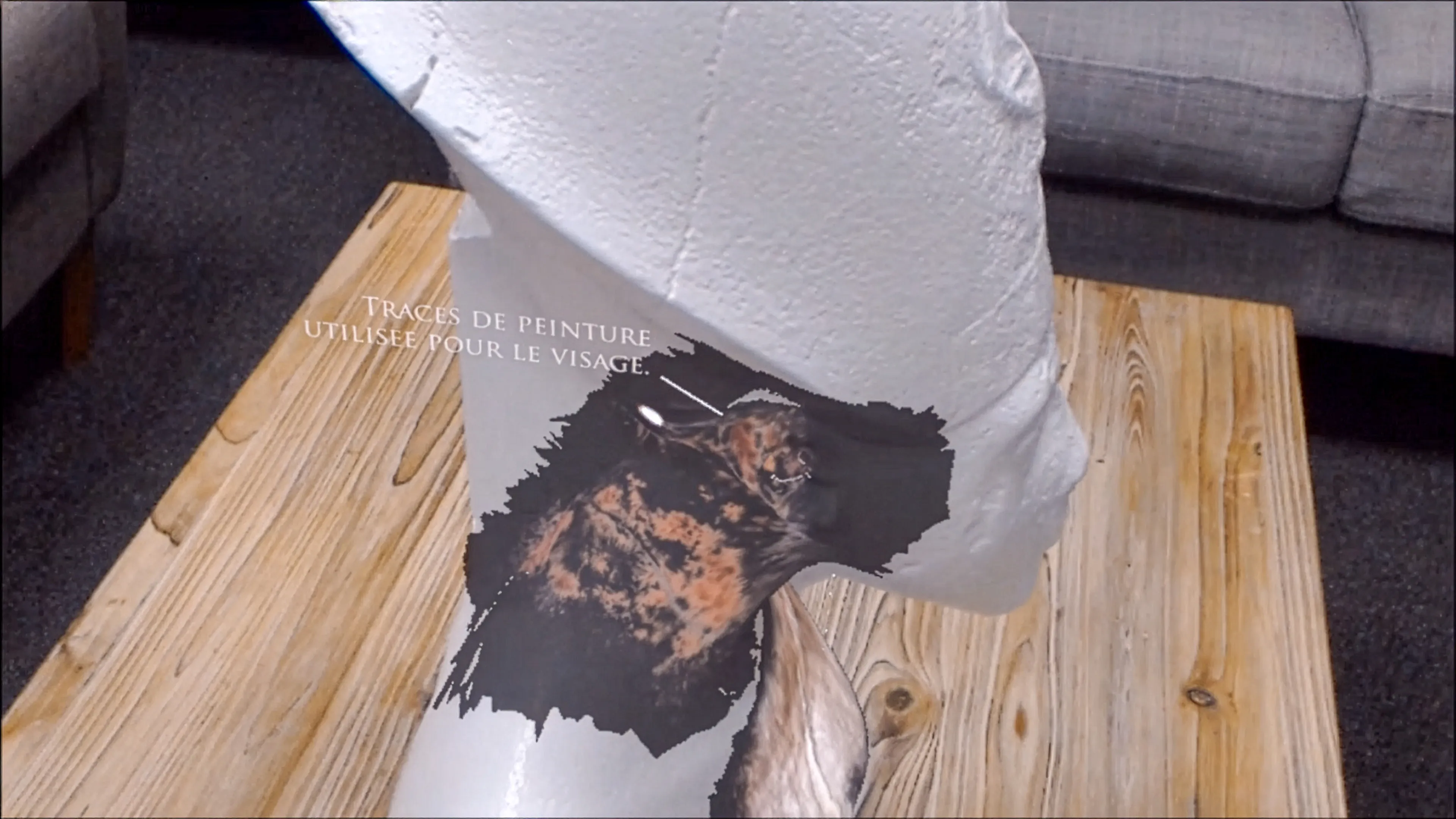 Visualisation en réalité mixte montrant les traces de peinture utilisées pour le visage sur un buste archéologique, dans une restitution polychromique interactive.