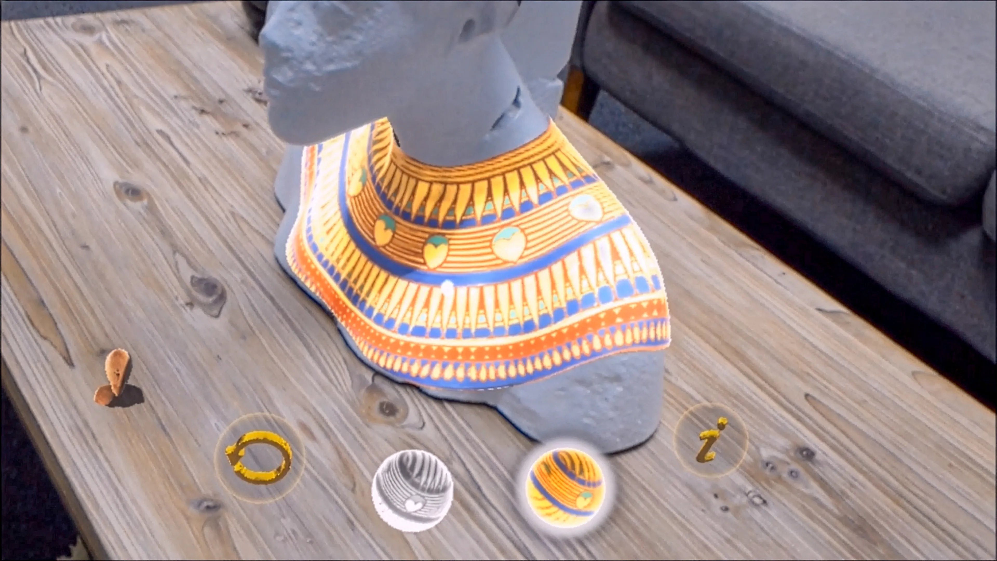 Reconstitution en réalité mixte d’un buste d'Akhenaton présentant la restitution des couleurs et motifs d’origine sur le collier, projetée en hologramme sur le modèle.