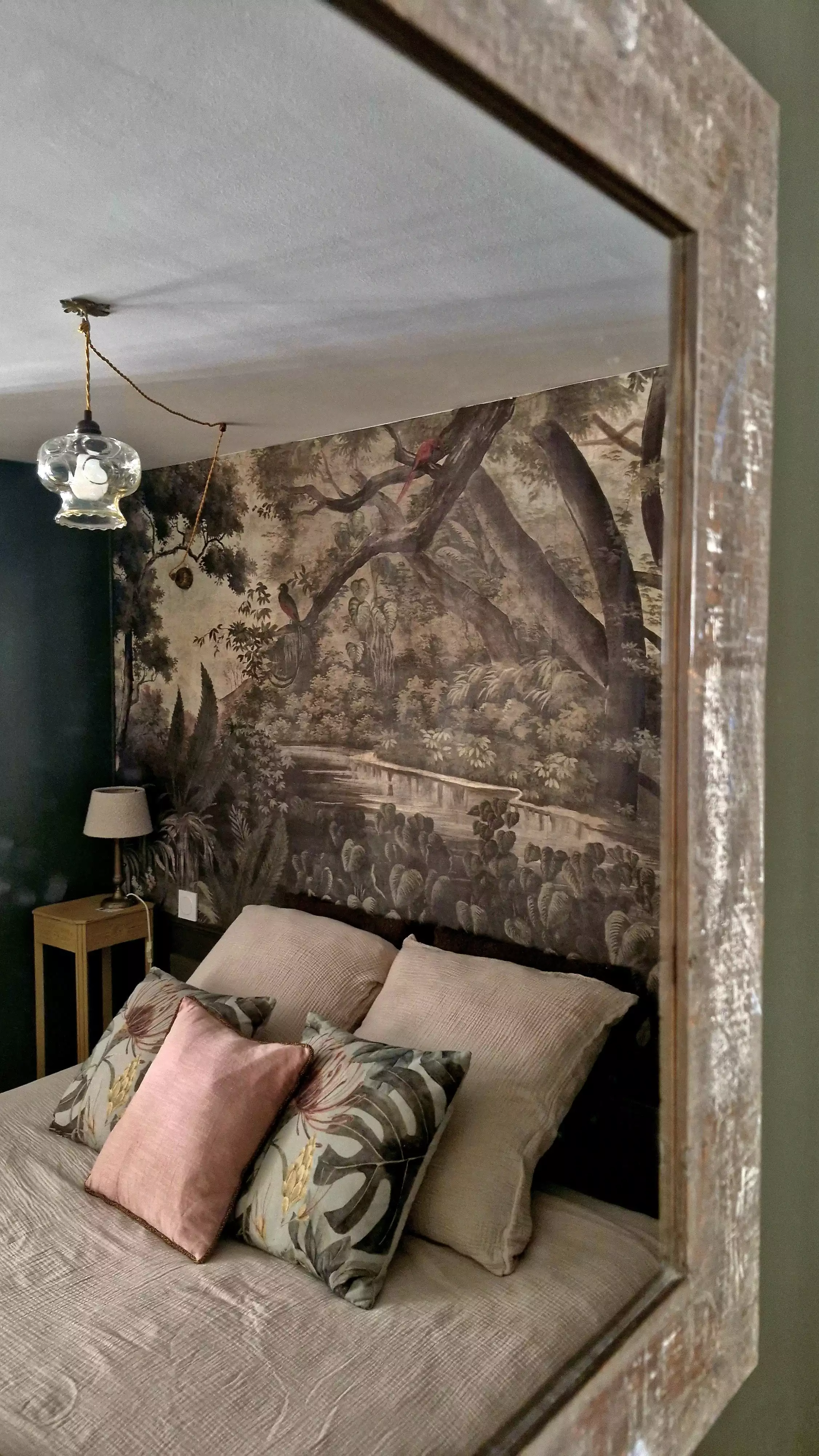 Photo du lit pris en reflet dans le miroir de la chambre