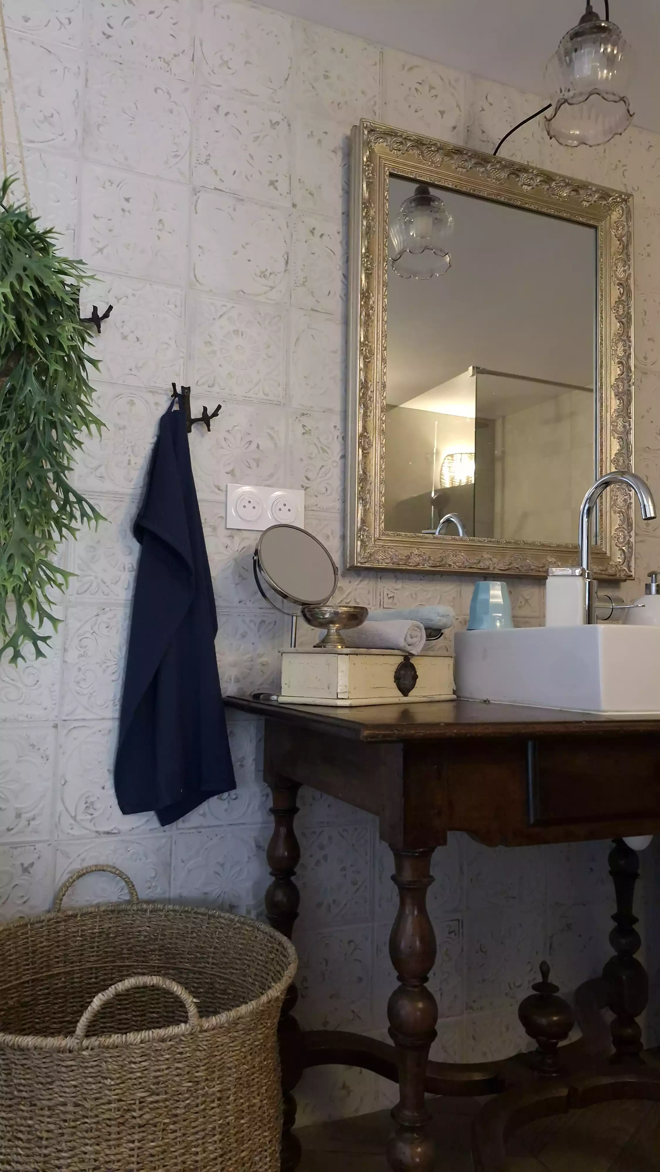 Photo du coin lavabo de la salle de bain, du miroir et de la corbeille en osier