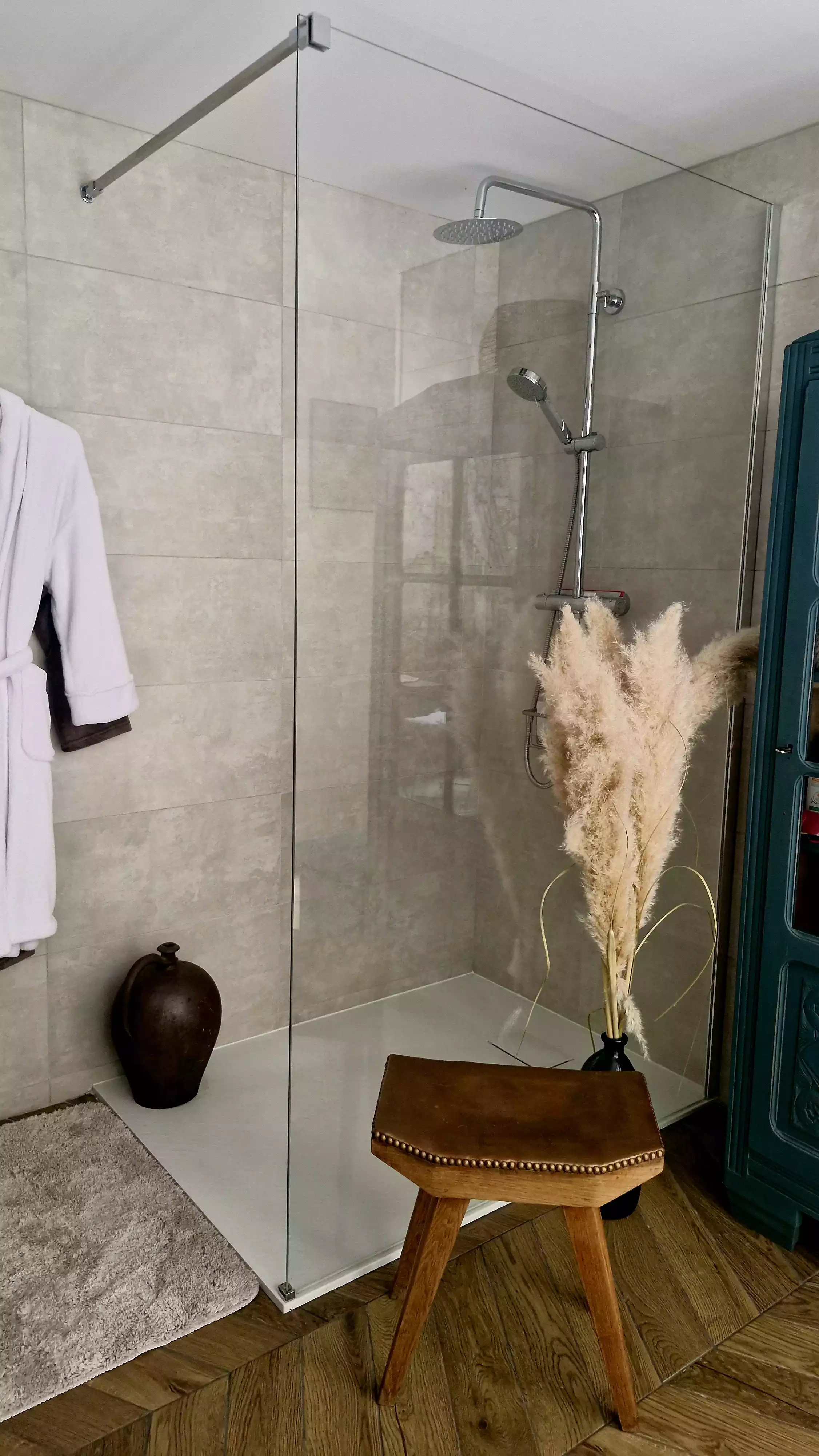 Photo de l'espace douche de la salle de bain, douche à l'italienne, et peignoirs accrochés au mur