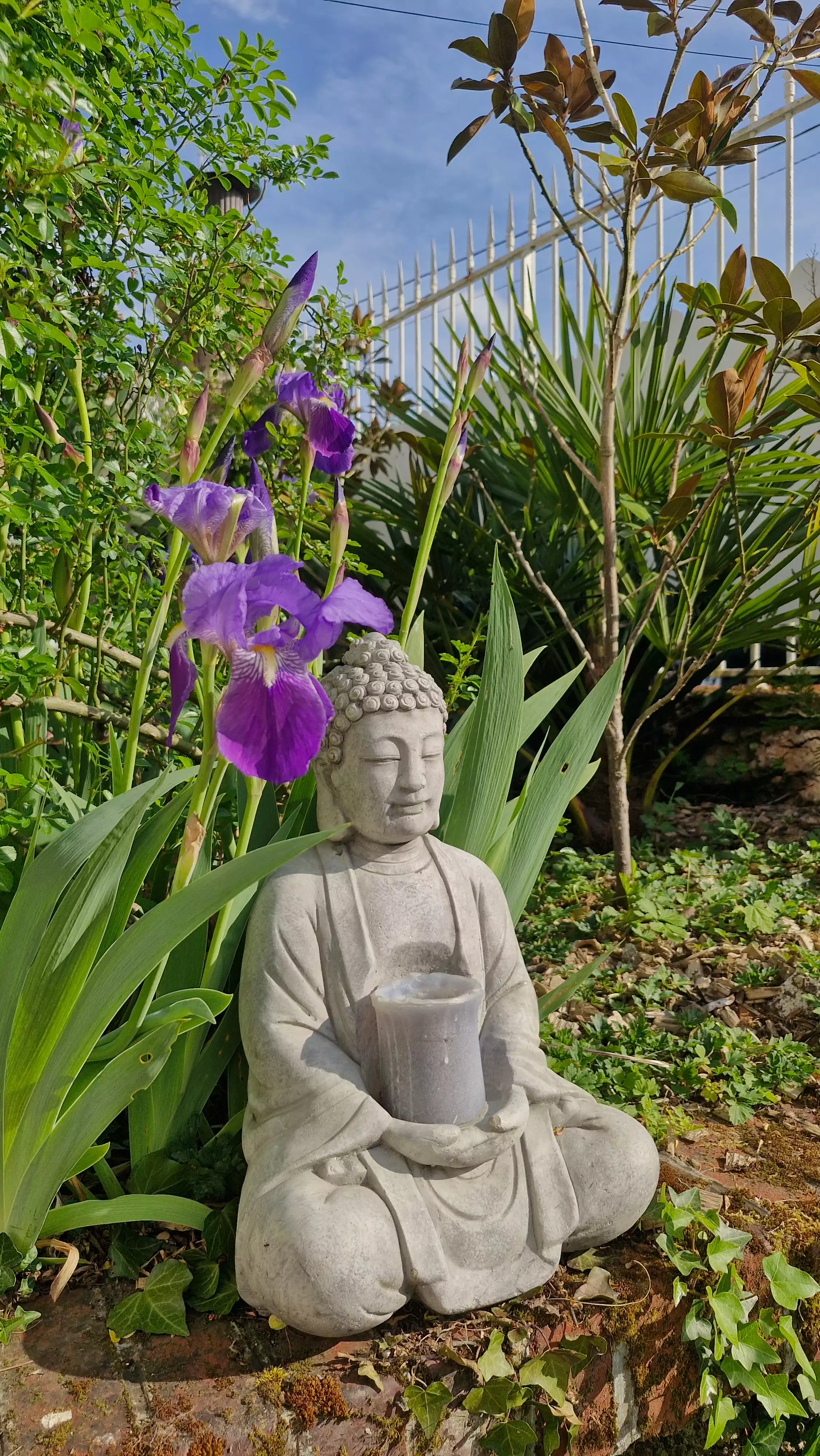 Photo d'une statue de Bouddha au milieu des fleurs du jardin