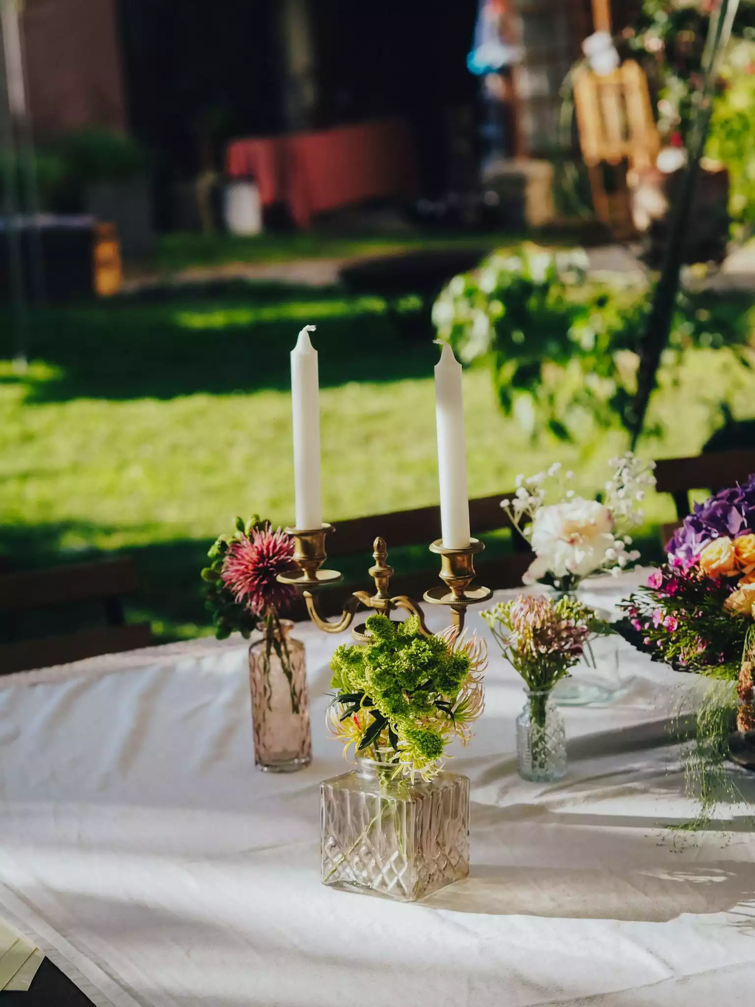 Photo d'une table décorée dans le jardin du presbytère, surplombée de deux bougies