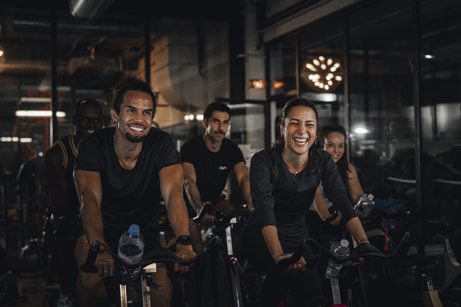 Adhérents souriants pendant un cours de vélo en groupe