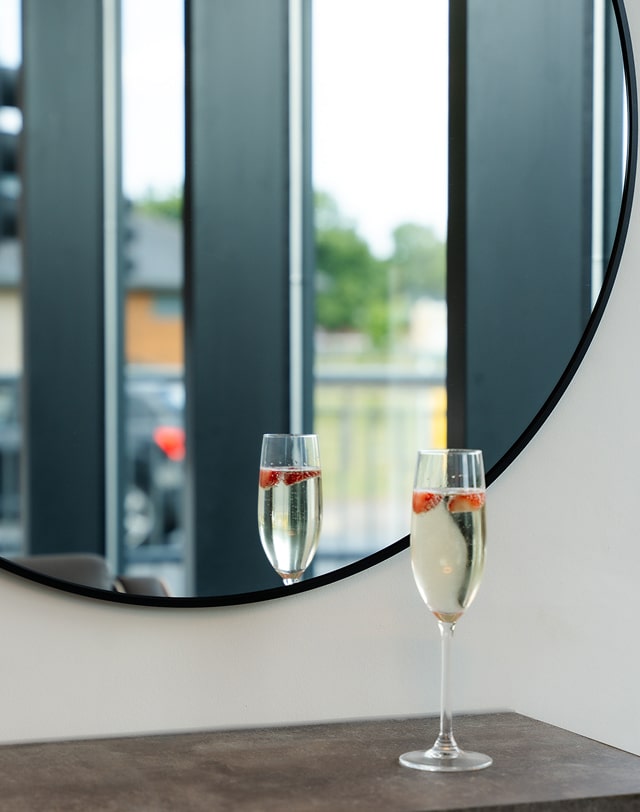 Glass of champagne next to a mirror