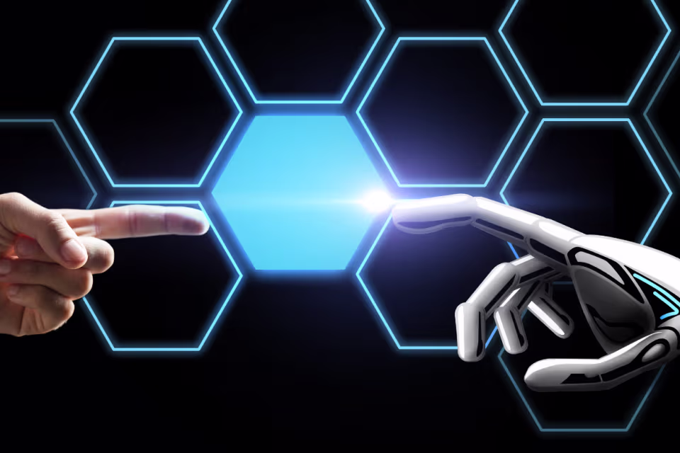Menschliche Hand zeigt mit dem Zeigefinger auf eine leuchtende Roboterhand vor einem Hintergrund mit beleuchteten blauen Hexagonen.