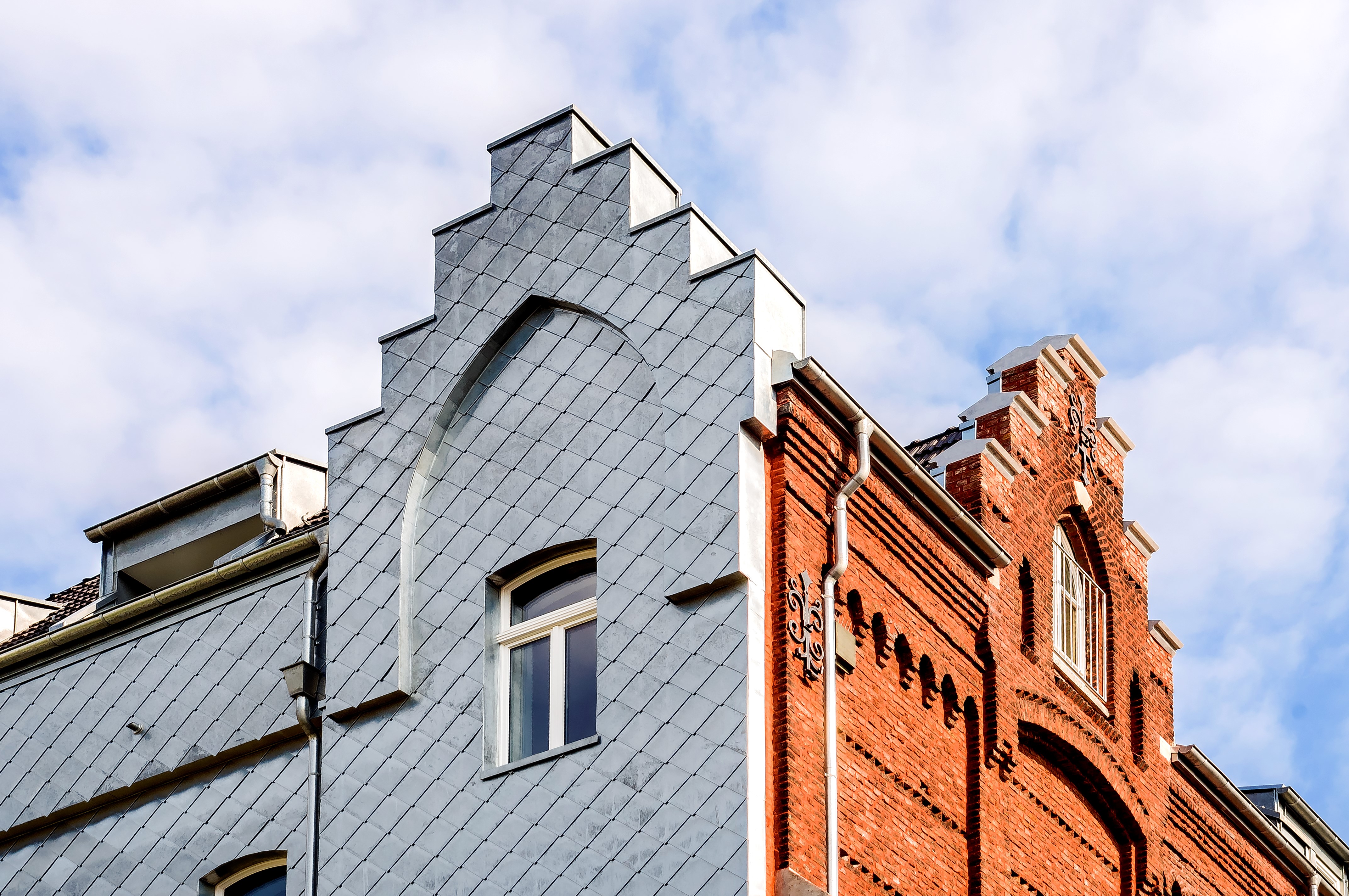 Historisches Gebäude des Guter Hirte Wohnprojekts in Aachen mit neugotischer Backsteinfassade.