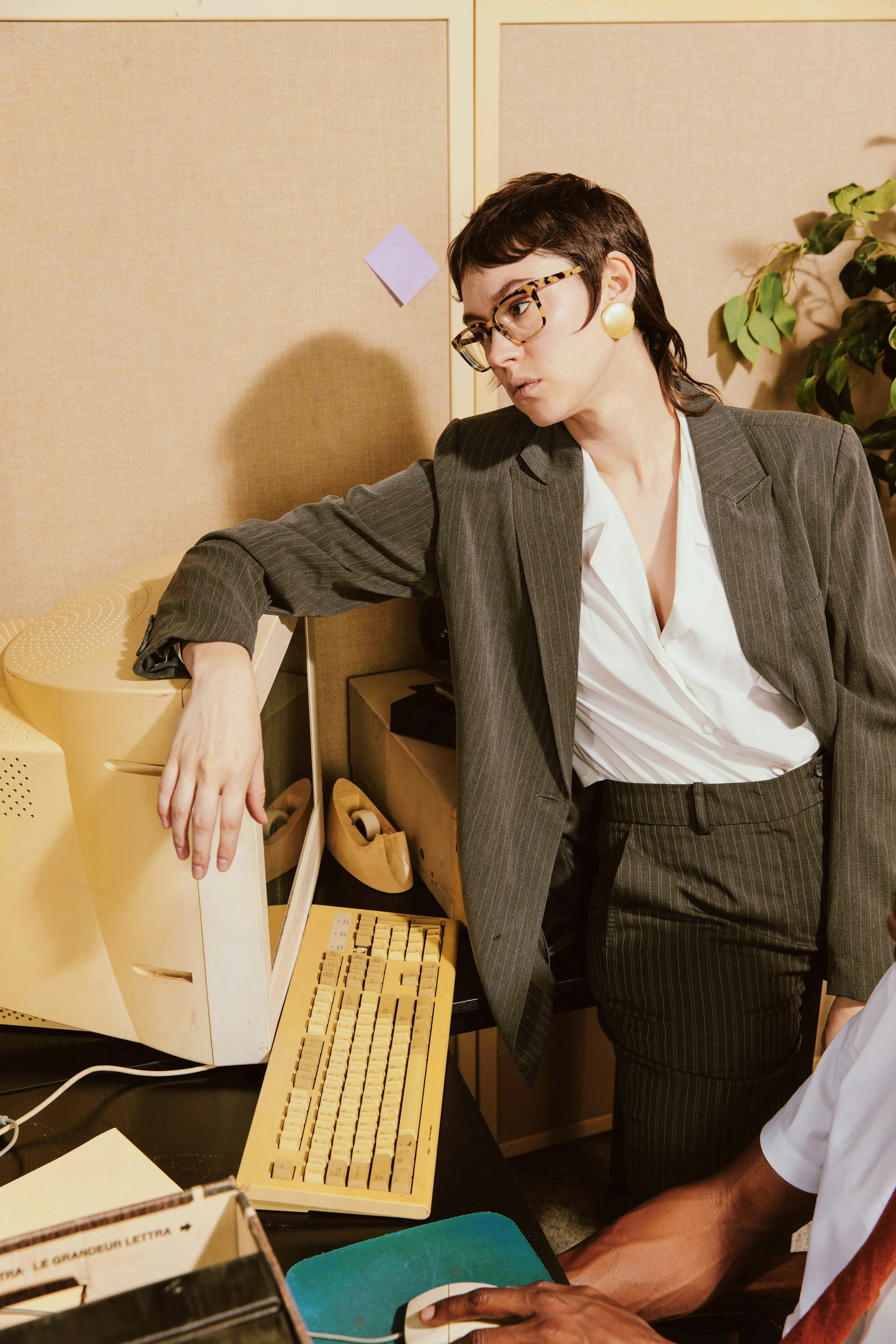 Office worker leaning on desktop computer
