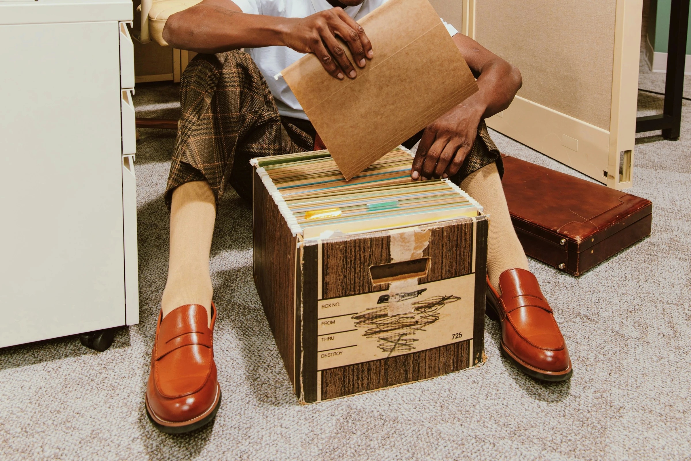 Office worker rooting through box of files