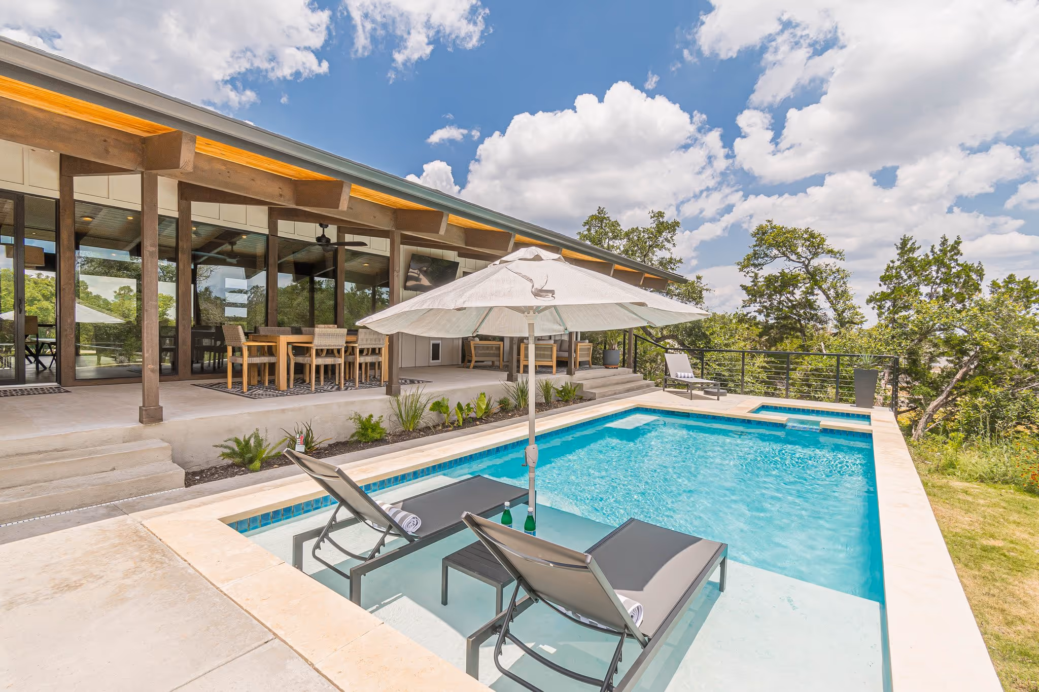 An angled view of a pool with outdoor lounge chairs sitting in the pool.