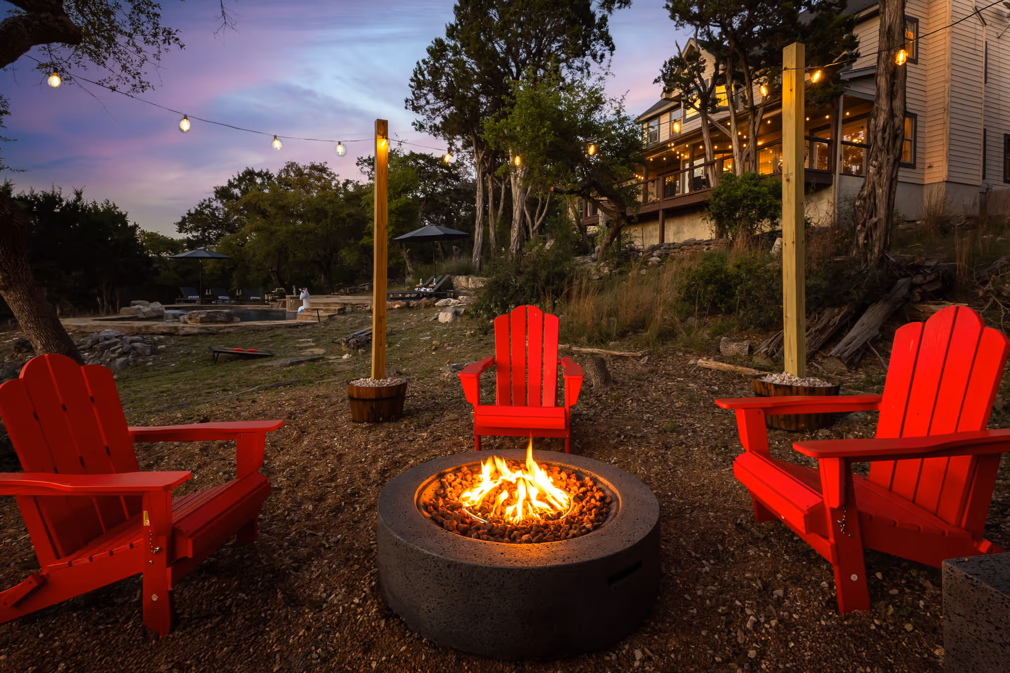 3 red chairs around an outdoor firepit.