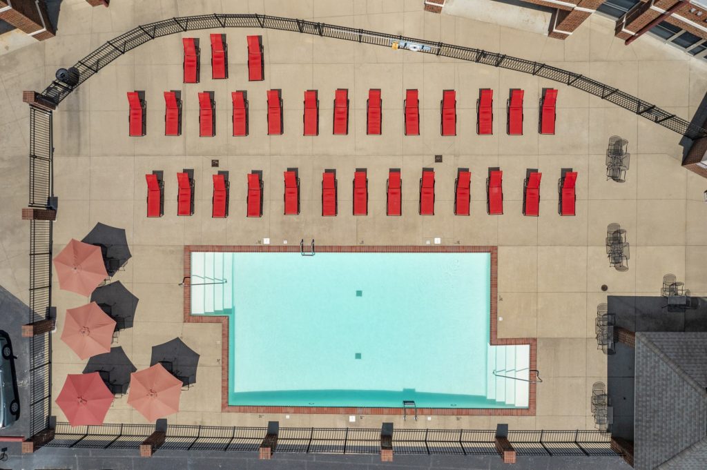 Swimming pool aerial shot with lounge chairs