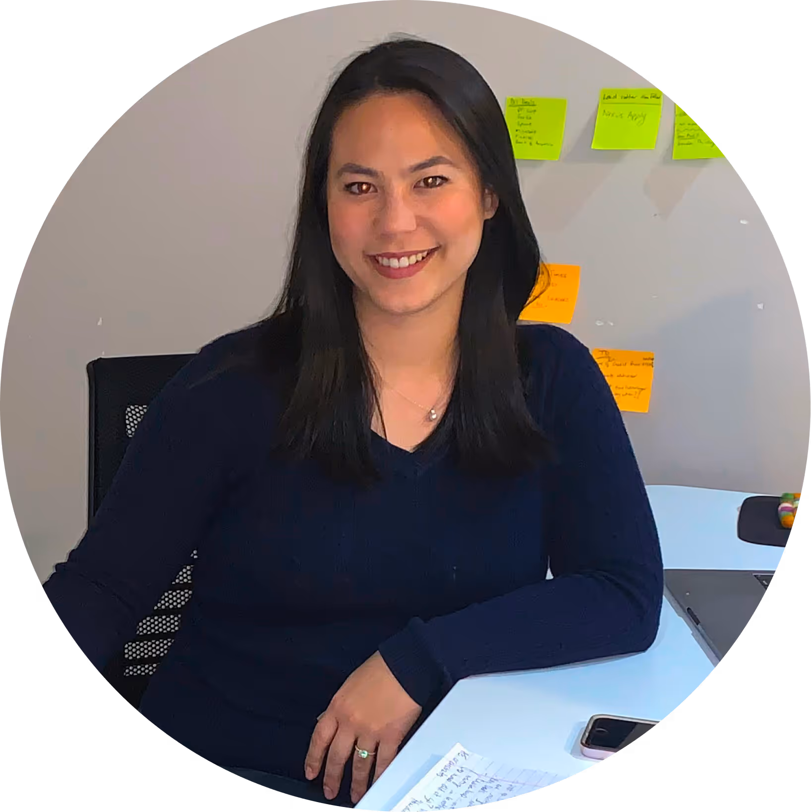 Woman smiling at desk with sticky notes, representing Toronto MSP IT support team at Unified Technicians
