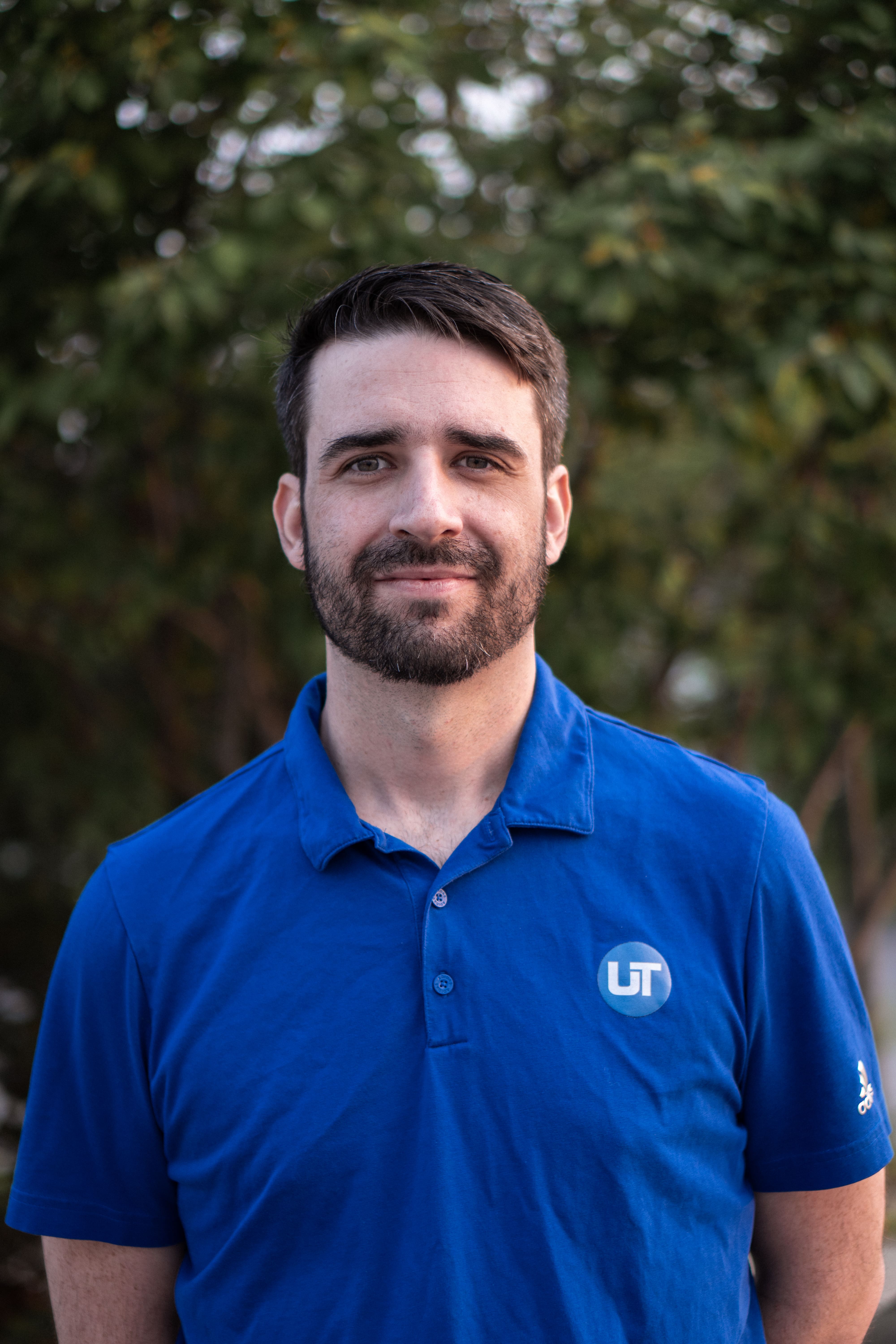 Unified Technicians IT support specialist smiling outdoors in branded blue polo shirt