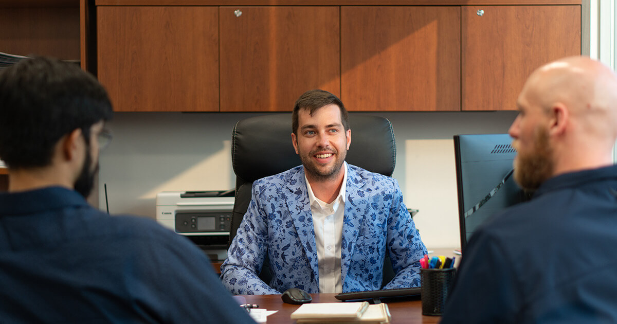 Unified Technicians IT consultant smiling during managed IT support meeting with clients in Toronto office