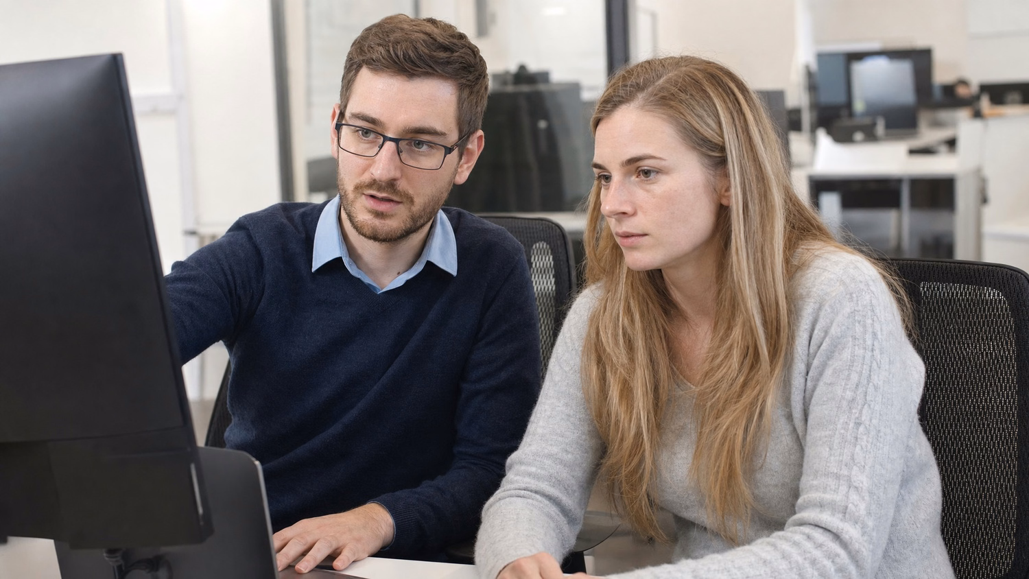 SIDE-BY-SIDE PAIR two people seated side by side reviewing something on a shar