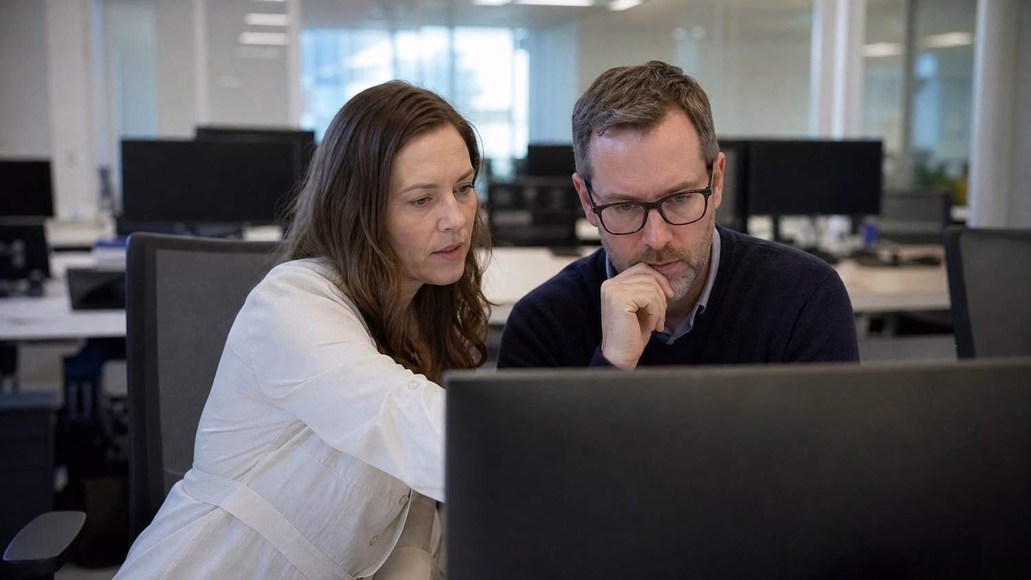 SIDE-BY-SIDE PAIR An IT professional  two people seated side by side reviewin
