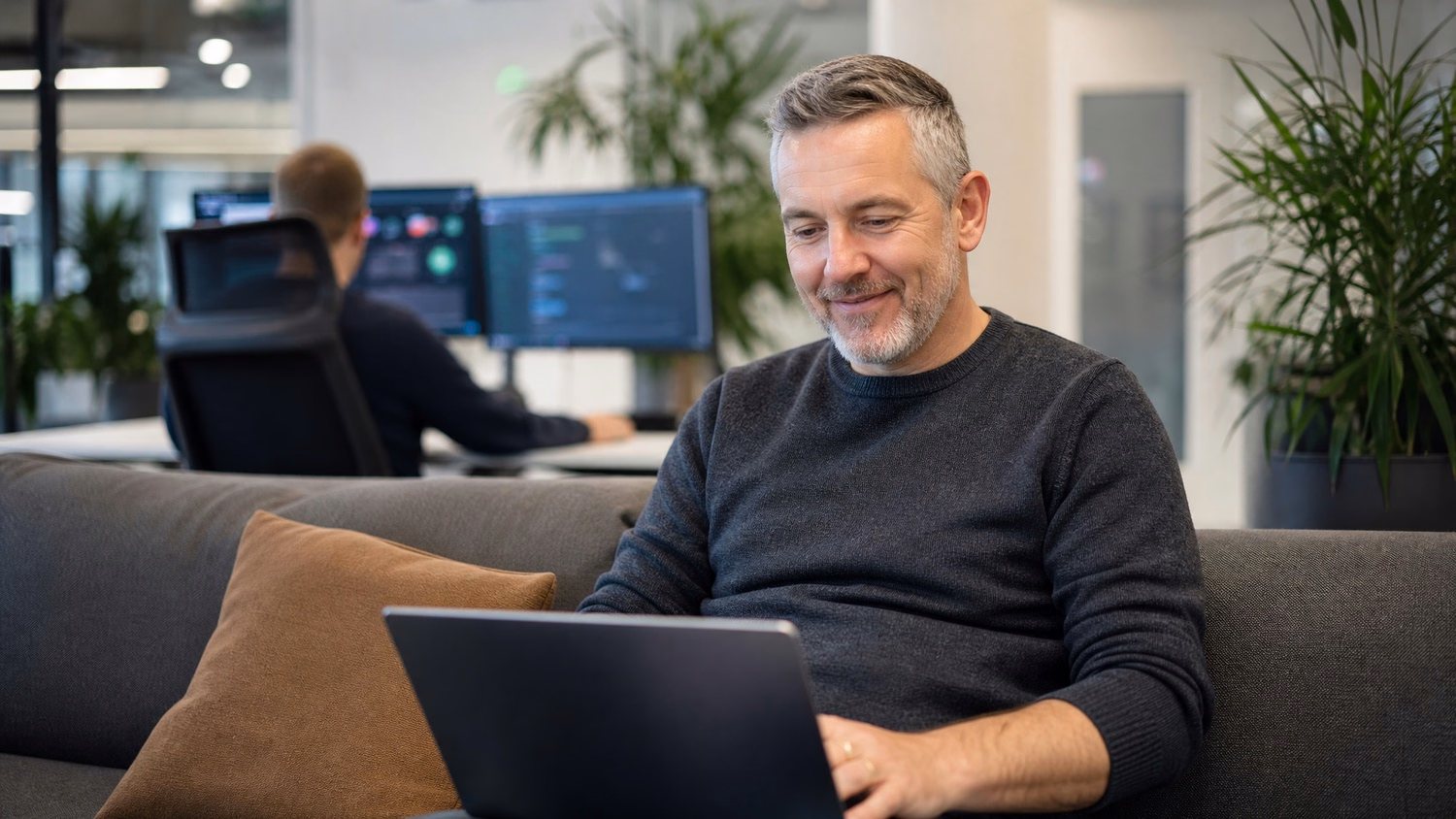 Man reviews vulnerability scan report on laptop in lounge 66