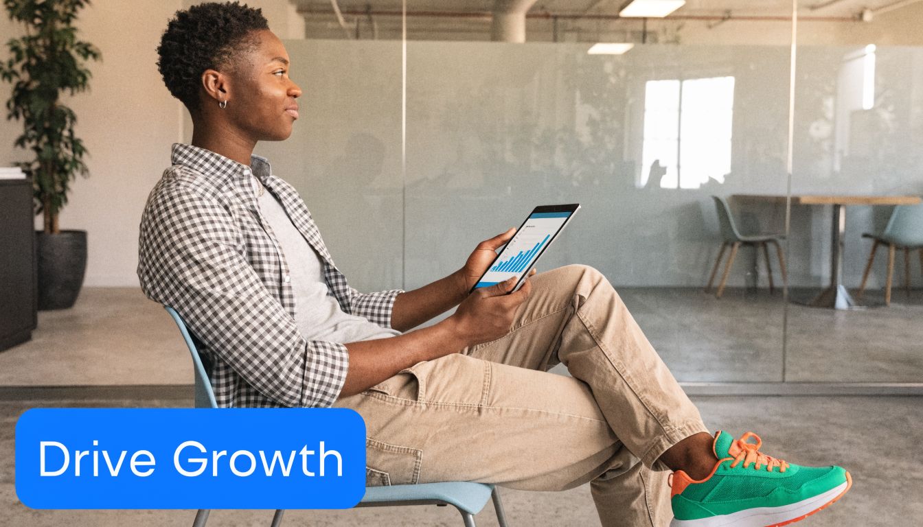 A person sitting in a modern office looking at a tablet displaying a growth chart graph.
