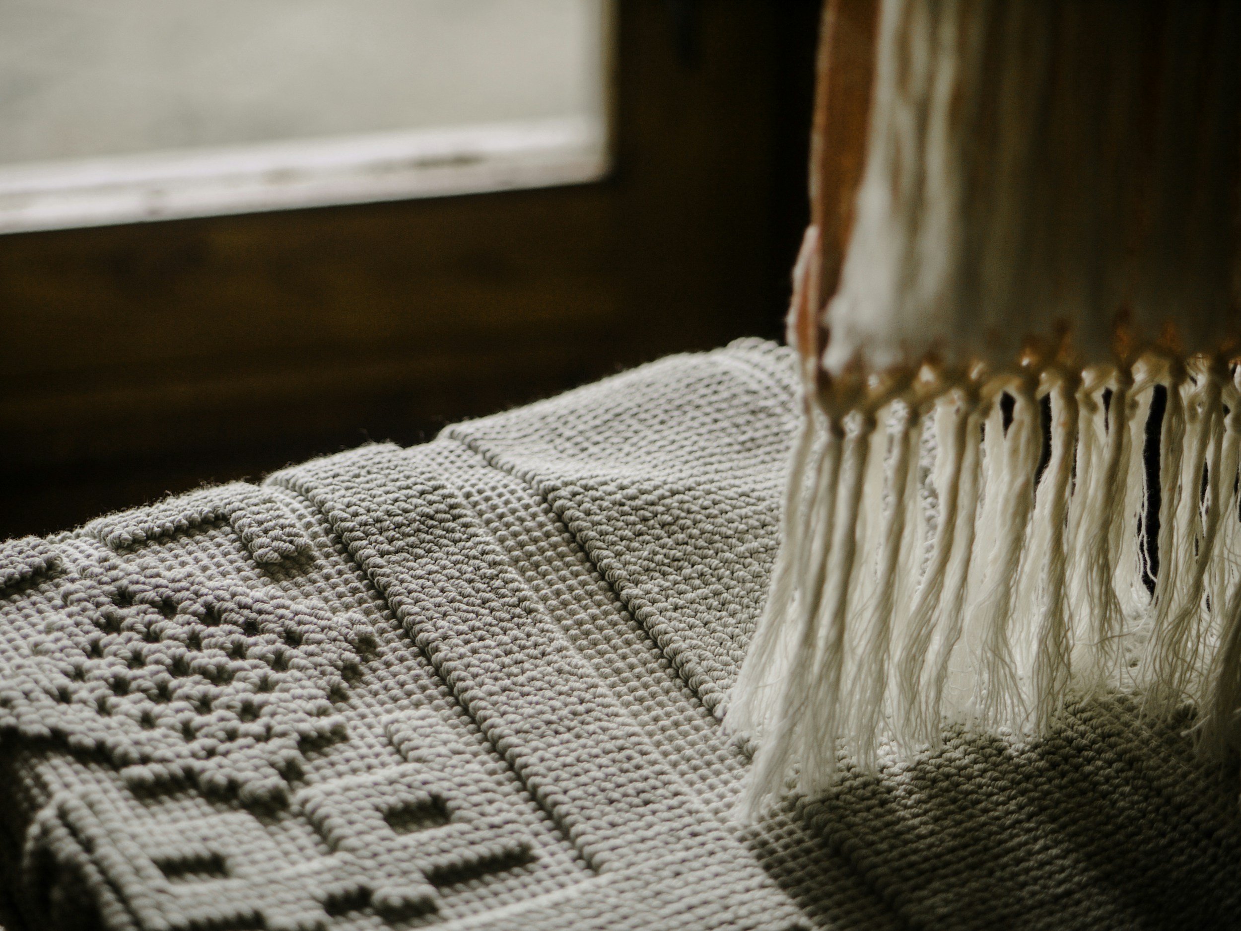 A close up shot of a knitted mat with beige and brown tones