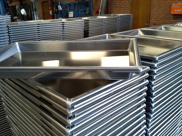 Stack of stainless steel freezer pans for seafood block production.