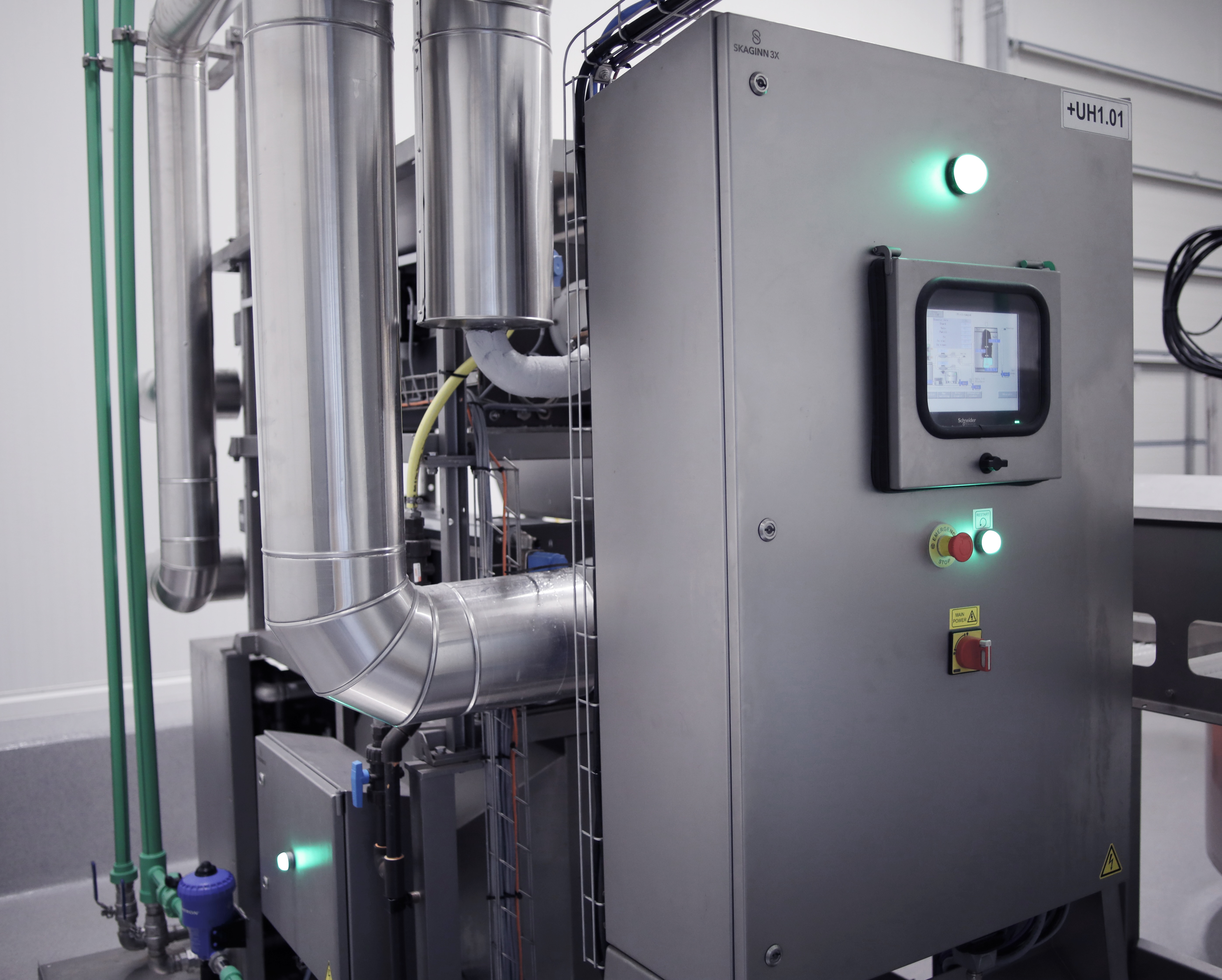 Stainless steel Fluid Ice machine with pipes and digital control panel.