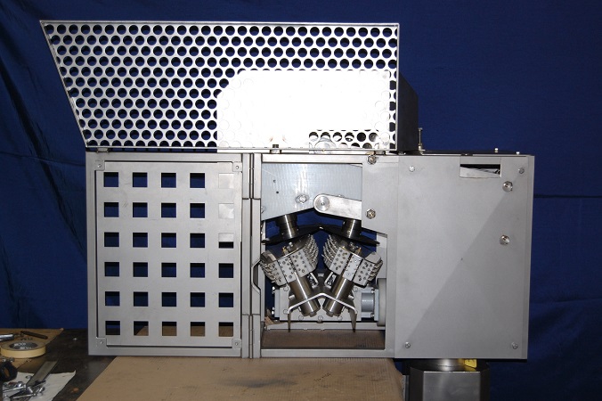 Stainless-steel fish head scalping machine with protective cover open.