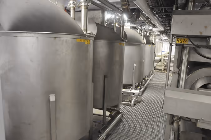 Row of stainless steel wash tanks in processing facility.
